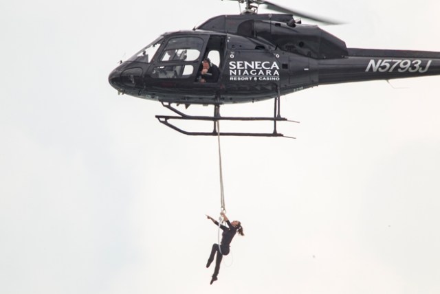 Aerialist Erendira Wallenda hangs beneath a helicopter during a stunt over the Horseshoe Falls at Niagara Falls, New York, June 15, 2017. / AFP PHOTO / Geoff Robins