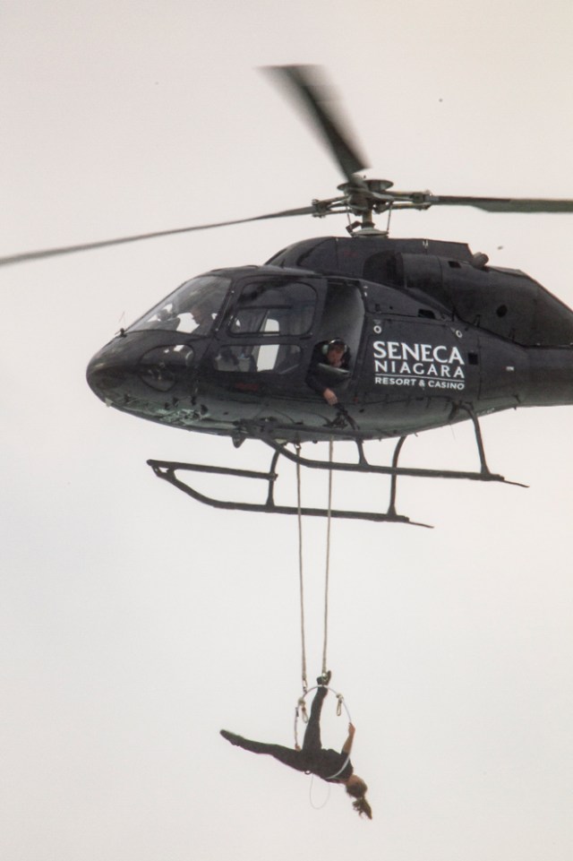 Aerialist Erendira Wallenda hangs beneath a helicopter during a stunt over the Horseshoe Falls at Niagara Falls, New York, June 15, 2017. / AFP PHOTO / Geoff Robins