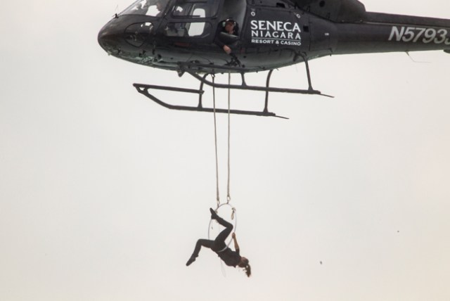 Aerialist Erendira Wallenda hangs beneath a helicopter during a stunt over the Horseshoe Falls at Niagara Falls, New York, June 15, 2017. / AFP PHOTO / Geoff Robins