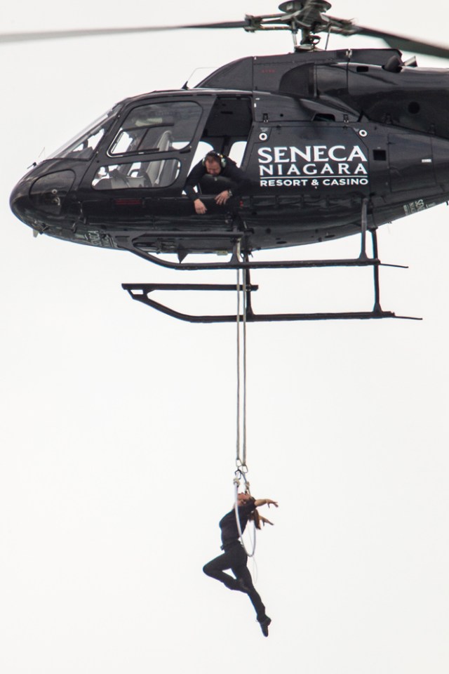 Aerialist Erendira Wallenda hangs beneath a helicopter during a stunt over the Horseshoe Falls at Niagara Falls, New York, June 15, 2017. / AFP PHOTO / Geoff Robins