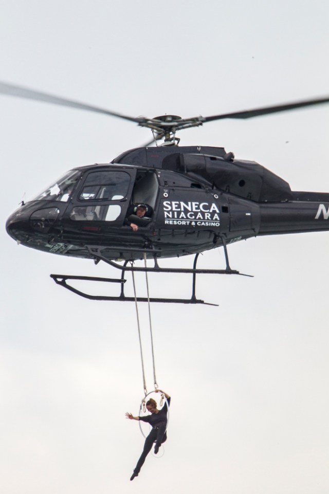 Aerialist Erendira Wallenda hangs beneath a helicopter during a stunt over the Horseshoe Falls at Niagara Falls, New York, June 15, 2017. / AFP PHOTO / Geoff Robins