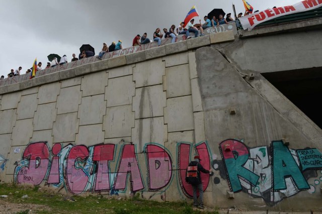 Opposition activists protest against the government of President Nicolas Maduro, at the Francisco Fajardo highway in Caracas, on July 1, 2017. Venezuela marks three months of violent protests within a political and economic crisis with protesters demanding President Nicolas Maduro's resignation and new elections. / AFP PHOTO / Federico Parra