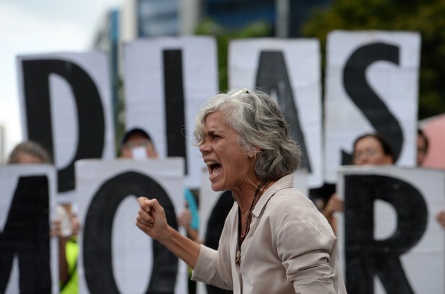 An opposition activist shouts slogans during a demonstration against Venezuelan President Nicolas Maduro in Caracas, on July 9, 2017. Venezuela hit its 100th day of anti-government protests on Sunday, one day after its most prominent political prisoner, Leopoldo Lopez, vowed to continue his fight for freedom after being released from jail and placed under house arrest. At least 91 people have died since non-stop street protests began on April 1. / AFP PHOTO / Federico PARRA