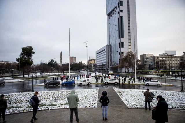 View of Santiago covered with snow on July 15, 2017.  An unusual snowfall --the first of such intensity since 2007-- surprised the inhabitants of the Chilean capital, causing a few power cuts and minor traffic jams, in particular in the eastern areas of the capital, the closest to the Andes mountain range. / AFP PHOTO / MARTIN BERNETTI