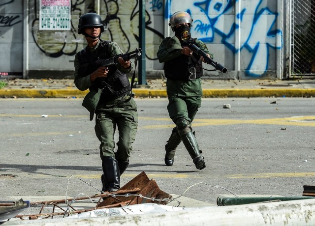 Bolivarian National Guard members clash with demonstrators during an anti-government protest in Caracas, on July 20, 2017. A 24-hour nationwide strike got underway in Venezuela Thursday, in a bid by the opposition to increase pressure on beleaguered leftist President Nicolas Maduro following four months of deadly street demonstrations. / AFP PHOTO / RONALDO SCHEMIDT