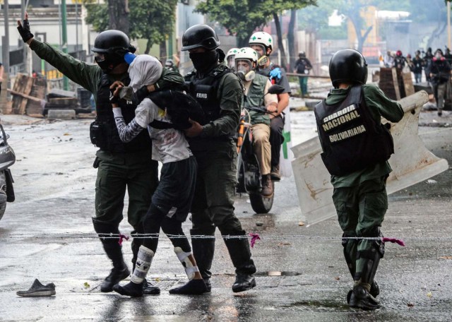 An anti-government activist is arrested during clashes in Caracas on July 28, 2017.  Protesters took over streets in Caracas on Friday in a show of defiance to President Nicolas Maduro, as the crisis gripping Venezuela turned deadlier ahead of a controversial weekend election that has earned international scorn.  / AFP PHOTO / FEDERICO PARRA