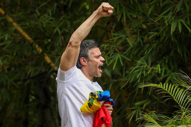 CAR30. CARACAS (VENEZUELA), 08/07/2017.- El opositor venezolano Leopoldo López saluda a seguidores hoy, sábado 8 de julio de 2017, en la entrada de su casa en Caracas (Venezuela). Leopoldo López saludó hoy desde dentro de su residencia en Caracas a la que llegó esta madrugada tras recibir una medida de arresto domiciliario que le sacó de la prisión militar en la que estaba recluido desde febrero de 2014, con una condena de 14 años de cárcel. EFE/MIGUEL GUTIÉRREZ