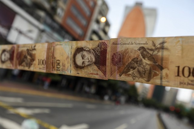 CAR108. CARACAS (VENEZUELA), 10/07/2017.- Manifestantes bloquean una vía con cintas hechas de monedas y billetes hoy, lunes 10 de julio de 2017, en Caracas (Venezuela). Los opositores venezolanos atendieron hoy a la convocatoria de realizar un "trancazo" de calles en todo el país contra la "dictadura" que se espera se extienda por diez horas, después de que la alianza antichavista intentara reducir esta protesta a solo dos horas. EFE/Miguel Gutiérrez