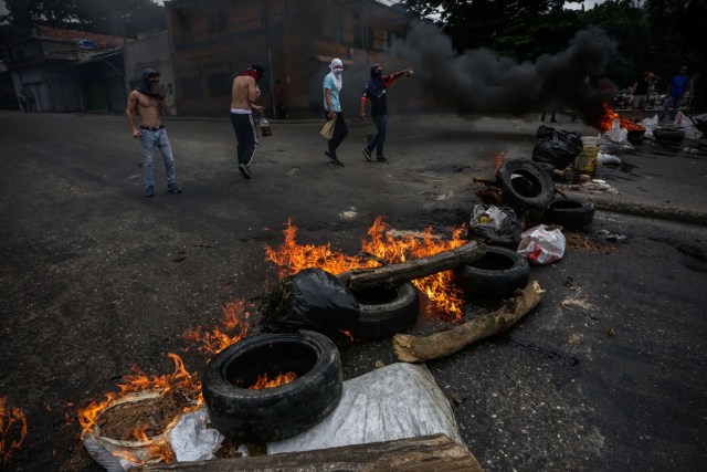 CAR136. CARACAS (VENEZUELA), 20/07/2017.- Manifestantes opositores bloquean una calle hoy, jueves 20 de julio de 2017, en Caracas (Venezuela). Sectores enteros de Caracas permanecen hoy cerrados al tráfico en seguimiento del paro general de 24 horas convocado por la oposición contra el presidente, Nicolás Maduro, en una nueva acción de protesta antigubernamental que atrancó las comunicaciones y provocó el cierre de buena parte de los negocios. EFE/Cristian Hernández