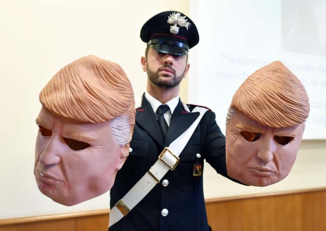 HAR02 TURÍN (ITALIA), 24/07/2017.- Un miembros de los Carabinari muestran unas máscaras con la imagen del presidente de Estados Unidos, Donald Trump, usadas por dos ladrones, durante una rueda de prensa en Turín, Italia, hoy, 24 de julio de 2017. Dos hermanos, Vittorio y Ivan Lafore, utilizaron las máscaras cuando trataban de robar en un cajero automático. Ambos fueron arrestados hoy en Turín. EFE/Alessandro Di Marco