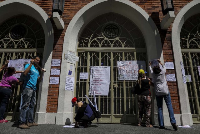 CAR10. CARACAS (VENEZUELA), 24/07/2017.- Manifestantes pegan carteles en rechazo a la Asamblea Constituyente hoy, lunes 24 de julio de 2017, en un colegio electoral de Caracas (Venezuela). Venezuela inicia hoy la semana decisiva para la elección de la Asamblea Nacional Constituyente convocada por el presidente, Nicolás Maduro, con los oficialistas entrando en la recta final de su campaña en medio de protestas y llamados a paro de los opositores en rechazo a esos comicios. EFE/Miguel Gutiérrez