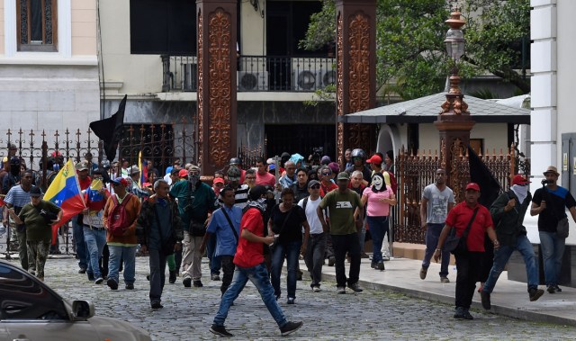 Supporters of Venezuelan President Nicolas Maduro storm the National Assembly building in Caracas on July 5, 2017 as opposition deputies hold a special session on Independence Day. A political and economic crisis in the oil-producing country has spawned often violent demonstrations by protesters demanding President Nicolas Maduro's resignation and new elections. The unrest has left 91 people dead since April 1. / AFP PHOTO / Juan BARRETO