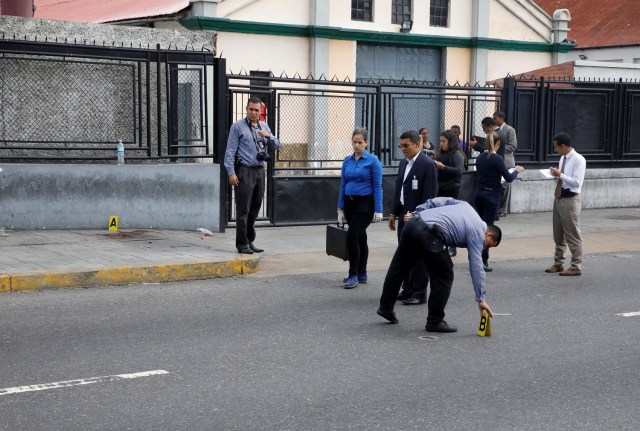 Forensic technicians stand at a crime scene where, according to the opposition, gunmen "apparently" shot dead and wounded several people during an opposition-organised unofficial plebiscite against President Nicolas Maduro's government and his plan to rewrite the constitution, in Caracas, Venezuela July 16, 2017. REUTERS/Carlos Garcia Rawlins