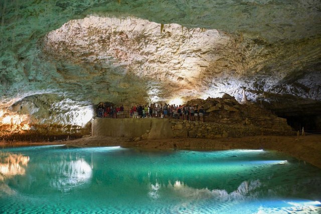 People visit a natural cave in Choranche, in the Vercors region near Grenoble, on August 3, 2017. Since the beginning of the heat wave, there has been an increase of at least 10 percent in the number of cave visitors, looking for beautiful natural sites, but also for underground freshness with temperatures around 15 Degrees Celsius. / AFP PHOTO / JEAN-PIERRE CLATOT