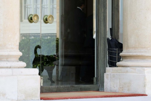 A dog named Nemo, adopted few days before by the French presidential couple from the SPA animal protection society, follows French president Emmanuel Macron (R) and Prime Minister Edouard Philippe (2ndR) ahead of a first government meeting after the summer break on August 28, 2017 at the Elysee Palace in Paris. / AFP PHOTO / LUDOVIC MARIN