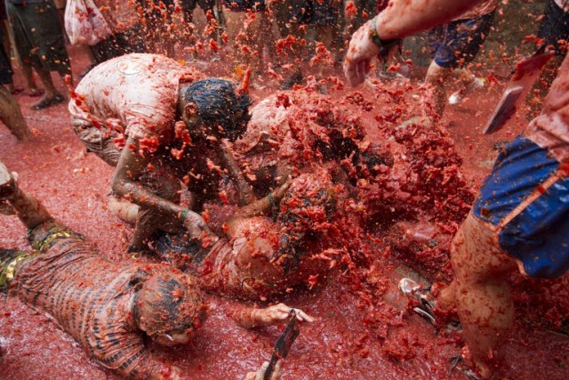 Revellers covered in tomato pulp take part in the annual "Tomatina" festival in the eastern town of Bunol, on August 30, 2017. The iconic fiesta -- which celebrates its 72nd anniversary and is billed at "the world's biggest food fight" -- has become a major draw for foreigners, in particular from Britain, Japan and the United States. / AFP PHOTO / JAIME REINA