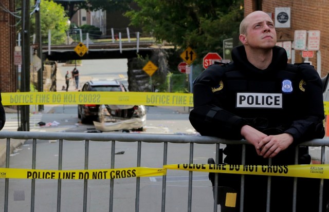 A Virginia State Trooper stands guard at the crime scene where a vehicle plowed into a crowd of counter protesters and two other vehicles (rear) near the "Unite the Right" rally organized by white nationalists in Charlottesville, Virginia, U.S., August 12, 2017. REUTERS/Jim Bourg