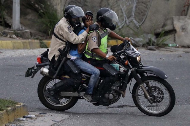 VEN32. CARACAS (VENEZUELA), 24/06/2017 - Fuerzas de seguridad detienen a un manifestante durante una protesta hoy, sábado 24 de junio de 2017, en Caracas (Venezuela). Los cuerpos de seguridad de Venezuela dispersaron hoy con gases lacrimógenos una manifestación que la oposición realizaba ante la base militar La Carlota, frente a la cual un joven fue asesinado el pasado jueves y a cuyos jardines decenas de manifestantes ingresaron este sábado, según constató Efe. EFE/Miguel Gutiérrez