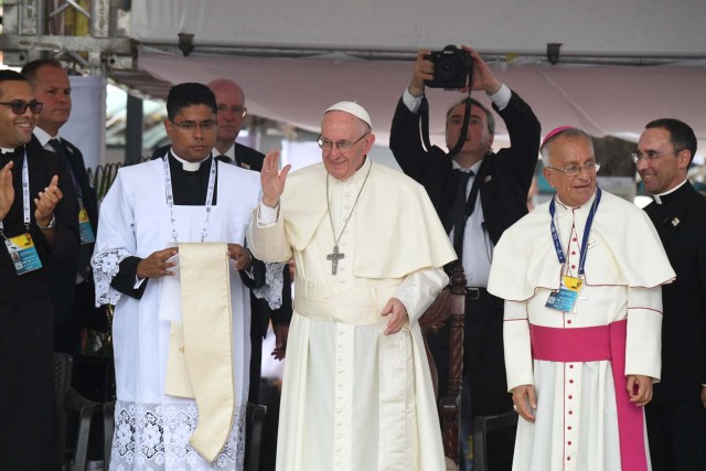 Pope Francis (C), flanked by Monsignor Jorge E.Rodriguez Carvajal (R), Archbishop of Cartagena, waves at the attendance during a ceremony on September 10, 2017 at San Francisco Square in Cartagena, Colombia. Nearly 1.3 million worshippers flocked to a mass by Pope Francis on Saturday in the Colombian city known as the stronghold of the late drug lord Pablo Escobar. / AFP PHOTO / Luis Acosta