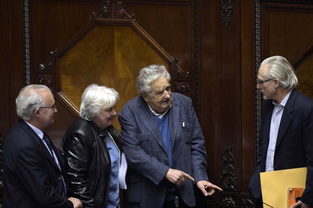 Uruguay's new vice-president Lucia Topolansky (2nd-L), accompanied by her husband, senator and former president Jode Mujica (2nd-R), talk with fellow lawmakers after her swearing-in ceremony in Montevideo, on September 13, 2017. Topolansky replaces Raul Sendic, who resigned on Saturday over allegations he used public money for personal shopping. / AFP PHOTO / MIGUEL ROJO