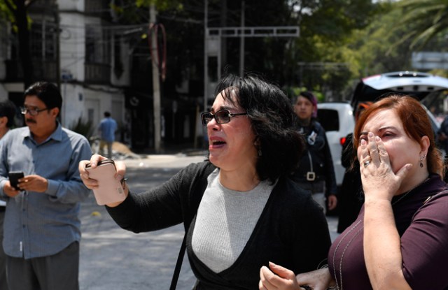 People react after a real quake rattled Mexico City on September 19, 2017 while an earthquake drill was being held in the capital. A powerful earthquake shook Mexico City on Tuesday, causing panic among the megalopolis' 20 million inhabitants on the 32nd anniversary of a devastating 1985 quake. The US Geological Survey put the quake's magnitude at 7.1 while Mexico's Seismological Institute said it measured 6.8 on its scale. The institute said the quake's epicenter was seven kilometers west of Chiautla de Tapia, in the neighboring state of Puebla. / AFP PHOTO / Omar TORRES