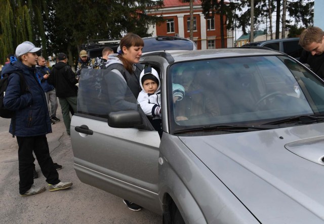 People evacuate from the town of Kalynivka following munition explosions at the nearby military depot on September 27, 2017. Ukranian authorities evacuated nearly 30,000 people September 27 from the central Vinnytsya region after a huge munitions depot caught fire and set off artillery shells and blasts prosecutors were treating as an act of "sabotage". It was the second major incident affecting a Ukrainian weapons storage site this year. Kiev blamed the first one in March on Moscow and its Russian-backed insurgents fighting Ukrainian forces in the war-wrecked east -- a charge both sides denied. / AFP PHOTO / Sergei SUPINSKY