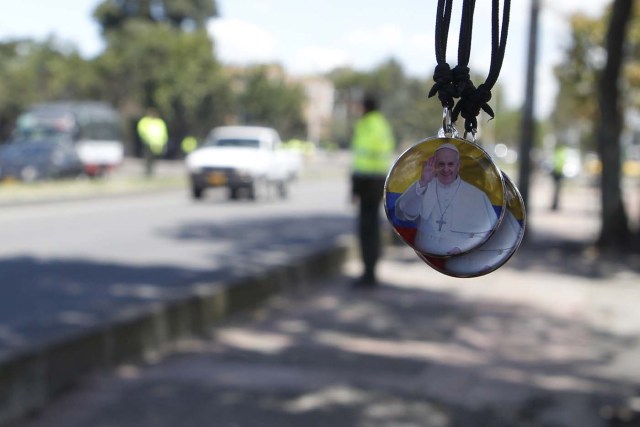 BOG505. BOGOTÁ (COLOMBIA), 06/09/2017.- Un hombre venden objetos con la imagen del papa Francisco hoy, miércoles 6 de septiembre de 2017, en Bogotá (Colombia). Centenares de policías y militares blindan hoy la avenida El Dorado, que lleva al aeropuerto internacional de Bogotá, para garantizar la seguridad durante el primer recorrido en papamóvil que hará el santo padre francisco tras su llegada esta tarde al país. EFE/LUIS EDUARDO NORIEGA A.