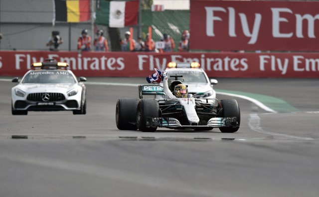 Mercedes' British driver Lewis Hamilton waves the Union flag after winning his fourth Formula One world title despite finishing the Mexican Grand Prix in ninth place, at the Hermanos Rodriguez circuit in Mexico City on October 29, 2017. / AFP PHOTO / YURI CORTEZ