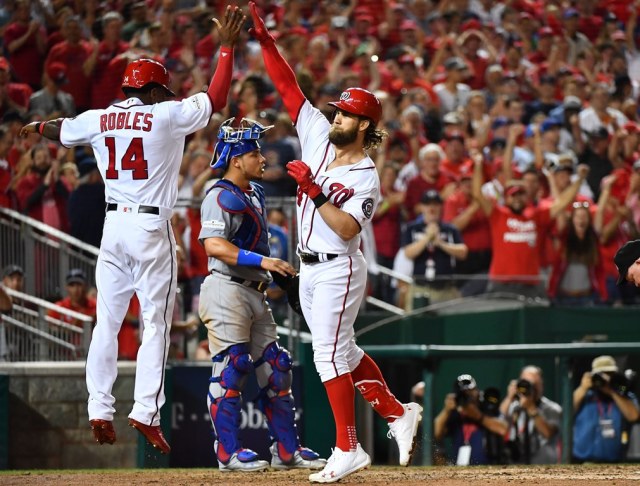 El jardinero derechos de los Nacionales de Washington, Bryce Harper, celebra con su compañero Victor Robles. Brad Mills-USA TODAY Sports