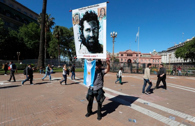 BAS11. BUENOS AIRES (ARGENTINA), 19/10/2017.- Una persona porta un cartel con la imagen del desaparecido Santiago Maldonado hoy, jueves 19 de octubre de 2017, durante la habitual ronda de los jueves de las Madres de Plaza Mayo para pedir justicia por el caso del desaparecido Santiago Maldonado en la Plaza de Mayo de Buenos Aires (Argentina). El cuerpo hallado el pasado martes en un río del sur de Argentina fue trasladado hoy a Buenos Aires, donde se le realizará una autopsia para intentar establecer si se trata del joven Santiago Maldonado, cuya desaparición el pasado 1 de agosto tras una protesta ha conmocionado al país. EFE/David Fernández