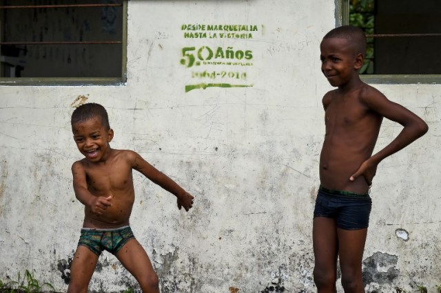 Los niños juegan junto a una pancarta de las FARC en Pital de la Costa, municipio de Tumaco, departamento de Nariño, Colombia el 31 de octubre de 2017. / Raul Arboleda