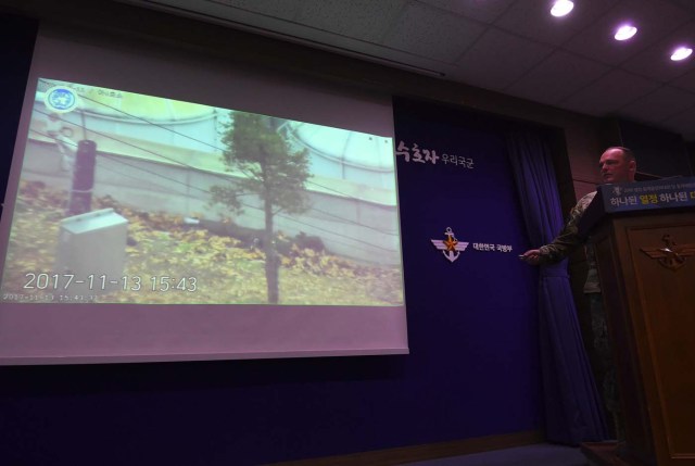 United Nations Command spokesman Colonel Chad G. Carroll shows a surveillance TV footage containing the moment of defection of a North Korean Soldier, during a press briefing at the Defence Ministry in Seoul on November 22, 2017. A North Korean soldier crossed the border into the South in breach of a 1953 armistice agreement as he pursued a defector who was shot last week, the US-led United Nations Command (UNC) said on November 22. / AFP PHOTO / JUNG Yeon-Je