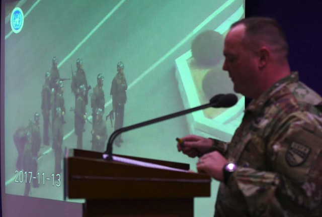 United Nations Command spokesman Colonel Chad G. Carroll shows a surveillance TV footage containing the moment of defection of a North Korean Soldier, during a press briefing at the Defence Ministry in Seoul on November 22, 2017. A North Korean soldier crossed the border into the South in breach of a 1953 armistice agreement as he pursued a defector who was shot last week, the US-led United Nations Command (UNC) said on November 22. / AFP PHOTO / JUNG Yeon-Je