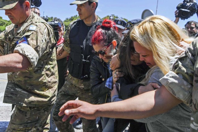 Relatives of 44 crew members of Argentine missing submarine, are escorted as they arrive at Argentina's Navy base in Mar del Plata, on the Atlantic coast south of Buenos Aires, on November 23, 2017. An unusual noise heard in the ocean near the last known position of the San Juan submarine was "consistent with an explosion," Argentina's navy announced Thursday. "An anomalous, singular, short, violent and non-nuclear event consistent with an explosion," occurred shortly after the last communication of the San Juan and its 44 crew, navy spokesman Captain Enrique Baldi told a news conference in Buenos Aires. / AFP PHOTO / EITAN ABRAMOVICH