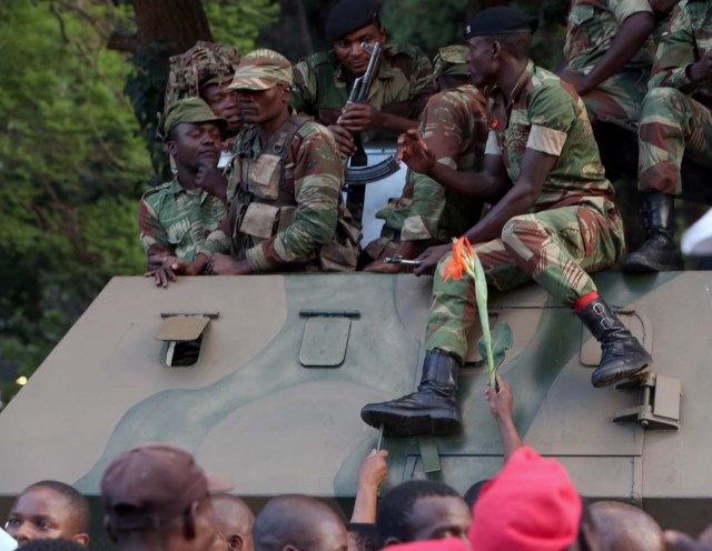 Soldiers sit atop a vehicle as Zimbabweans celebrate after President Robert Mugabe resigns in Harare, Zimbabwe November 21, 2017. REUTERS/Marius Bosch