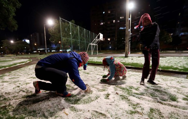 BOG36. BOGOTÁ (COLOMBIA), 01/11/2017.- Una familia juega con granizo hoy, miércoles 1 de noviembre de 2017, en Bogotá (Colombia). Una inusual granizada que cayó hoy en gran parte de Bogotá cubrió de blanco y causó caos en varios sectores por las inundaciones, paralización del tráfico en la hora pico y cortes de electricidad, aunque sin dejar víctimas, según las autoridades. EFE/Mauricio Dueñas Castañeda