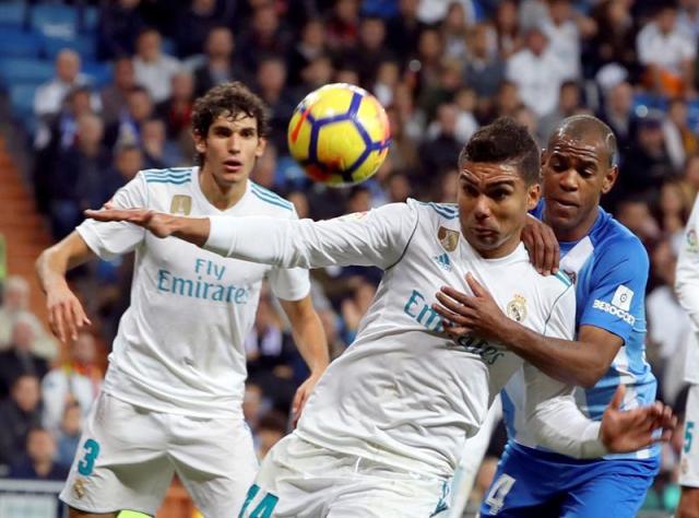 MADRID (ESPAÑA), 25/11/2017.- El centrocampista brasileño del Real Madrid Casemiro (c) disputa un balón con el delantero uruguayo del Málaga Diego Rolán (d) durante el partido correspondiente a la decimotercera jornada de LaLiga Santander disputado hoy en el estadio Santiago Bernabéu. EFE/J.J.Guillen