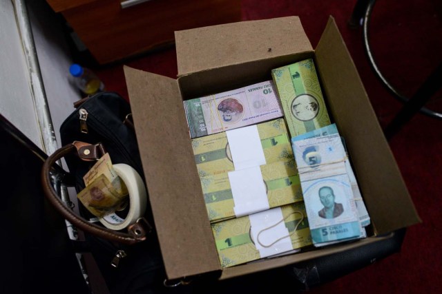 Stacks of bills of the new local community currency, the panal, launched in the "23 de Enero" working-class neighbourhood in Caracas, are seen at the BanPanal communal bank on December 15, 2017. A collective in a hilltop shantytown in Caracas created its own currency, the panal, in an attempt to fight chronic shortages of cash in inflation-ridden Venezuela. The currency can be exchanged locally for staples like sugar, rice (produced in the neighborhood itself), and bread. / AFP PHOTO / FEDERICO PARRA