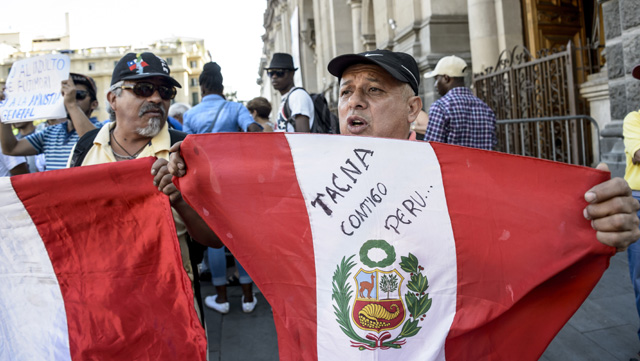 Peruvian citizens living in Chile hold a protest against Peruvian President Pedro Pablo Kuczynski's humanitarian pardon to Peru's jailed ex-president Alberto Fujimori, in Santiago, Chile on December 25, 2017.  Kuczynski on Sunday granted a humanitarian pardon to ex-president Fujimori, who has been hospitalized since Decembre 23 and is serving a 25-year sentence for crimes against humanity. / AFP PHOTO / Martin BERNETTI