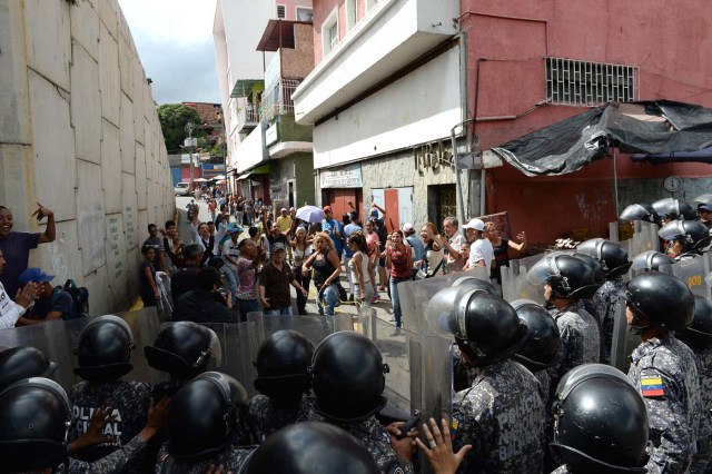 Venezuelans take part in a protest against the shortage of food in Caracas on December 28, 2017. As Venezuelans protest in Caracas demanding the government's prommised pork -the main dish of the Christmas and New Year's dinner-, President Nicolas Maduro attributes the shortage to international sabotage. / AFP PHOTO / FEDERICO PARRA