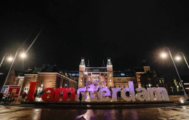 A tourist poses for photos outside the Rijksmuseum in central Amsterdam, Netherlands, November 30, 2017. Picture taken November 30, 2017. REUTERS/Yves Herman