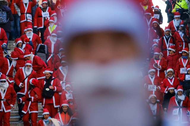 People dressed as Santa Claus run during a Christmas race in Venice, Italy December 17, 2017. REUTERS/Manuel Silvestri