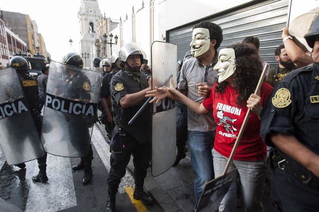 LIM411. LIMA (PERÚ), 25/12/2017.- Manifestantes enfrentan a la policía antimotines que impide el paso de una marcha en contra del indulto al expresidente Alberto Fujimori hoy, lunes 25 de diciembre de 2017, en Lima (Perú). Miles de personas se manifestaron en las principales ciudades de Perú para protestar por el indulto concedido por el presidente del país, Pedro Pablo Kuczynski, al exmandatario Alberto Fujimori, que le exime de terminar de cumplir una condena de 25 años de prisión por violaciones de los derechos humanos. EFE/EDUARDO CAVERO