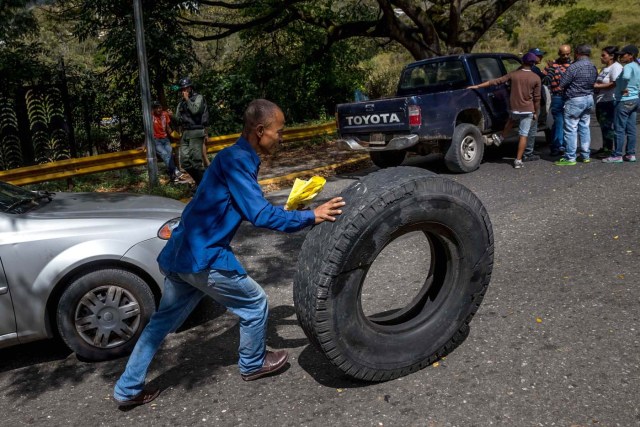 ACOMPAÑA CRÓNICA: VENEZUELA CRISIS. CAR04. CARACAS (VENEZUELA), 27/12/2017.- Un hombre mueve una rueda durante una manifestación hoy, miércoles 27 de diciembre del 2017, en Caracas (Venezuela). Venezuela vive una Navidad con focos de protestas pues en la última semana se han registrado, casi a diario, manifestaciones por falta de "todo" lo que incluye gas doméstico, alimentos y agua, algo que, sumado a la grave crisis económica, ha convertido estas fiestas en "las peores" de los últimos tiempos. EFE/MIGUEL GUTIÉRREZ