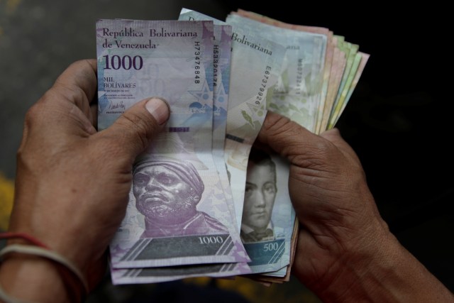 Un trabajador de una gasolinera de PDVSA cuenta bolívares en Caracas. 1 de diciembre de 2017. REUTERS/Marco Bello