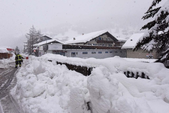 Workers remove snow beside the Zermatt train station after heavy snowfall and avalanches trapped more than 13,000 tourists at Zermatt, which is one of Switzerland's most popular ski stations on January 09, 2018. The snow has blocked all roads and the train leading to the resort in the southern Swiss canton of Valais, which was also hit by some power outages. / AFP PHOTO / Mark Ralston