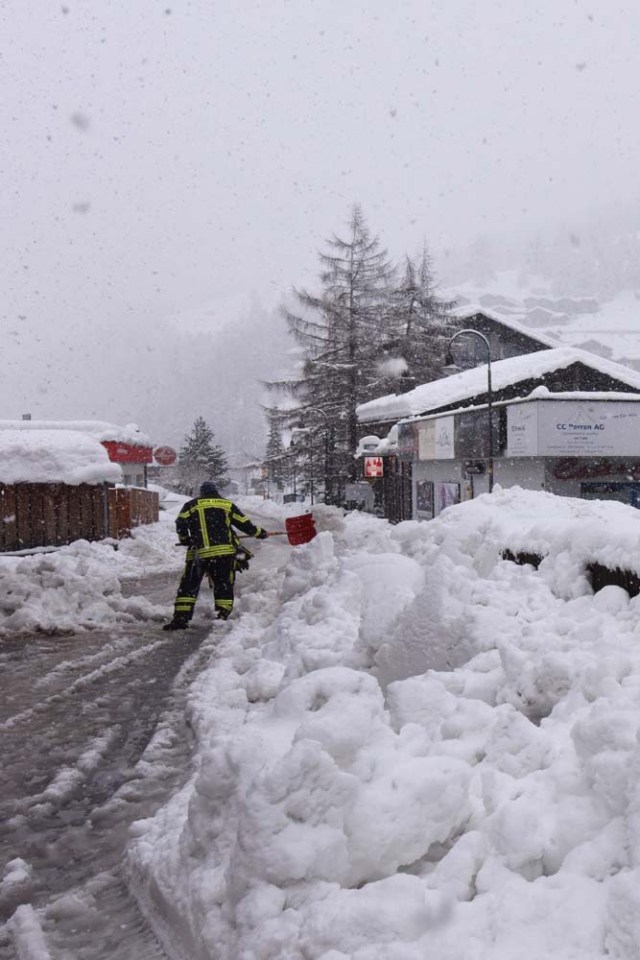 Workers remove snow beside the Zermatt train station after heavy snowfall and avalanches trapped more than 13,000 tourists at Zermatt, which is one of Switzerland's most popular ski stations on January 09, 2018. The snow has blocked all roads and the train leading to the resort in the southern Swiss canton of Valais, which was also hit by some power outages. / AFP PHOTO / Mark Ralston