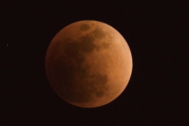 The moon is seen during a lunar eclipse, referred to as the "super blue blood moon", in Beijing on January 31, 2018. Skywatchers were hoping for a rare lunar eclipse that combines three unusual events -- a blue moon, a super moon and a total eclipse -- which was to make for a large crimson moon viewable in many corners of the globe. / AFP PHOTO / NICOLAS ASFOURI