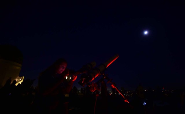 Telescopes are used for a closer view as people attend the lunar eclipse celebration at Griffith Observatory in Los Angeles, California in the early hours of January 31, 2018, to witness the Super Blue Blood Moon, an event not seen since 1866 when three fairly common lunar happenings occur at the same time. Stargazers across large swathes of the globe -- from the streets of Los Angeles to the slopes of a smouldering Philippine volcano -- had the chance to witness a rare "super blue blood Moon" Wednesday, when Earth's shadow bathed our satellite in a coppery hue.The celestial show is the result of the Sun, Earth, and Moon lining up perfectly for a lunar eclipse just as the Moon is near its closest orbit point to Earth, making it appear "super" large. / AFP PHOTO / Frederic J. BROWN