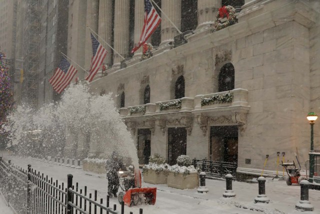 A worker clears snow from the front of the New York Stock Exchange during a snowstorm in New York, U.S., January 4, 2018. REUTERS/Lucas Jackson